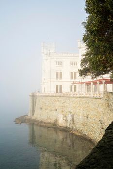 Trieste, Italy. 24 February 2921. A panoramic view of Miramare castle, Trieste, in a foggy day