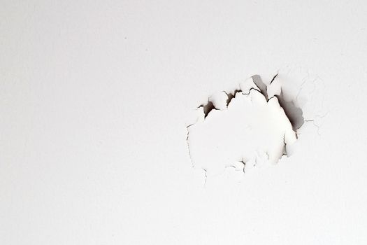 White color paint peeling off on ceiling house. Under the roof