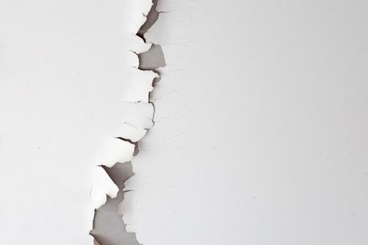 White color paint peeling off on ceiling house. Under the roof