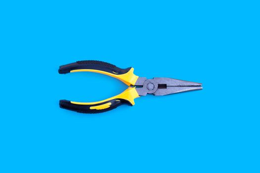Yellow pliers on blue background.
