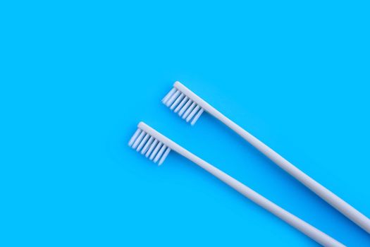 Toothbrushes on blue background. Top view