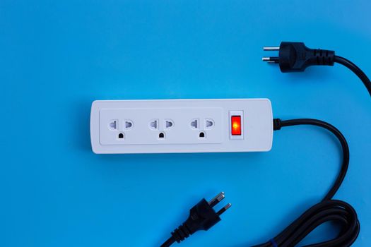 Electrical power strip and plug on blue background. Top view