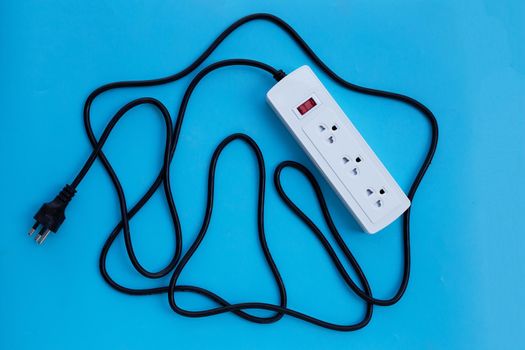 Electrical power strip and plug on blue background. Top view