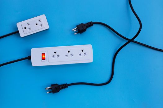 Electrical power strip and plug on blue background. Top view