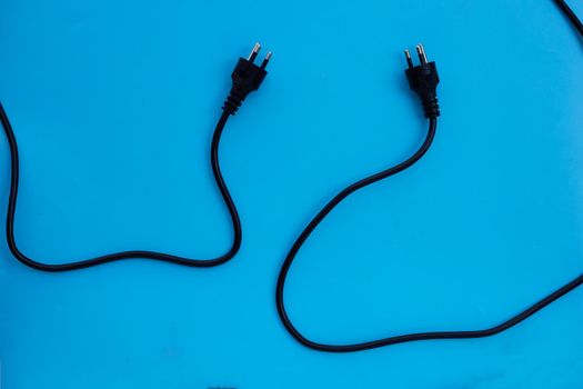 Electrical power strip and plug on blue background. Top view