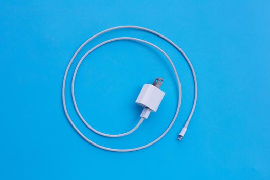 Mobile phone charger on blue background.