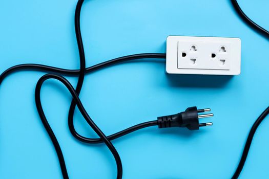 Electrical power strip and plug on blue background. Top view