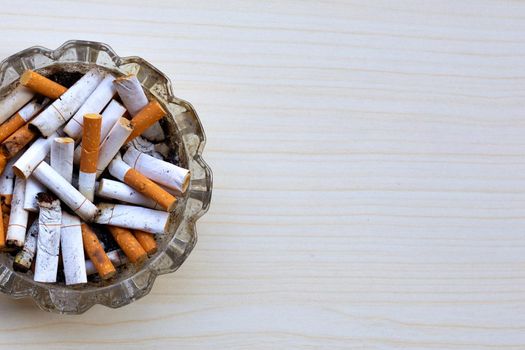 Cigarette butts in glass ashtray 