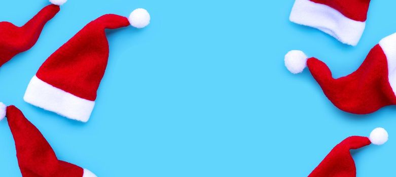 Merry Christmas and Happy Holidays. Santa hats on blue background. 