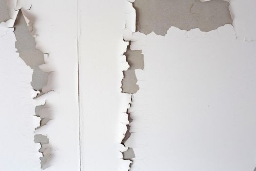 White color paint peeling off on ceiling house. Under the roof