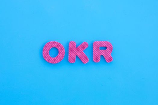 OKR alphabets on blue background.