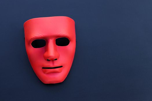 Red mask on the dark background. 