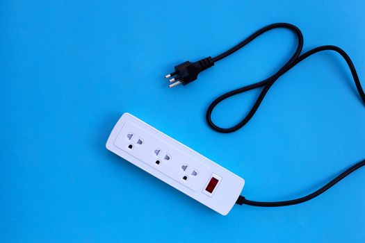 Electrical power strip and plug on blue background. Top view