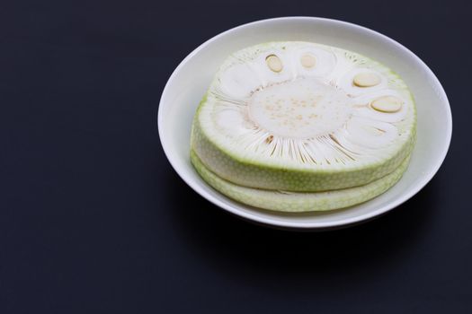 Sliced young jackfruit on dark background.