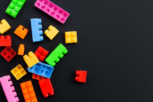 Plastic building blocks on dark background.