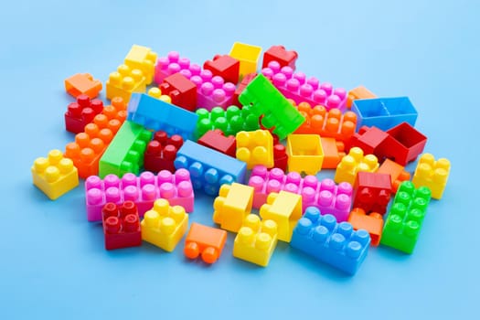Plastic building blocks on blue background.