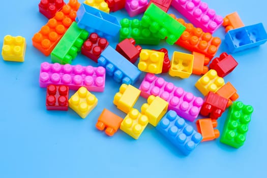 Plastic building blocks on blue background. 