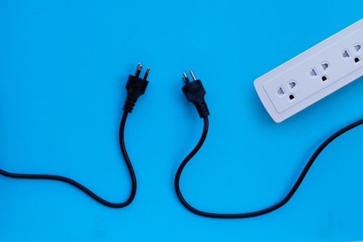 Electrical power strip with plugs on blue background. Top view