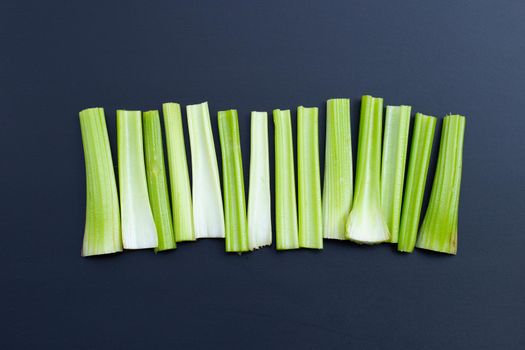 Fresh celery on dark background. Top view
