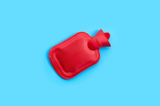 Hot water bag on blue background. Copy space