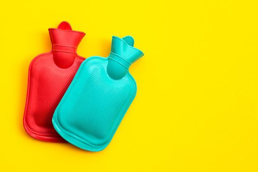 Hot water bags on yellow background. Copy space