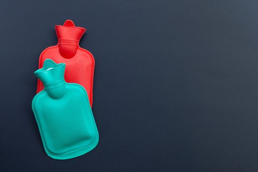 Hot water bags on dark background. Copy space