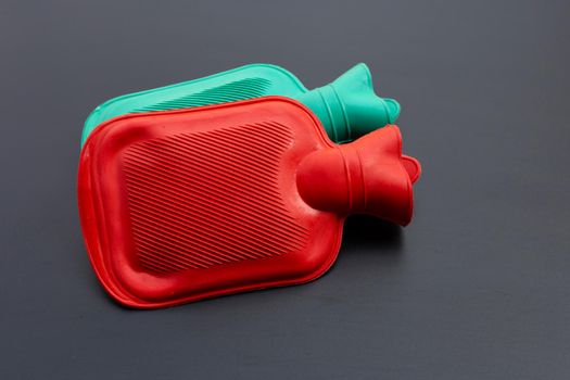 Hot water bags on dark background. Copy space