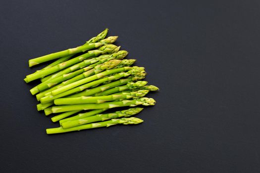 Fresh asparagus on dark background. Copy space