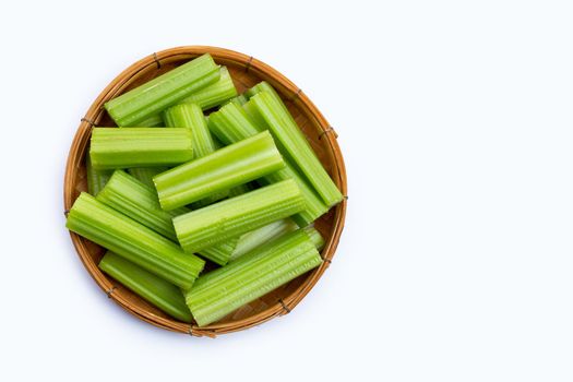 Fresh celery in wooden basket on white background. Copy space