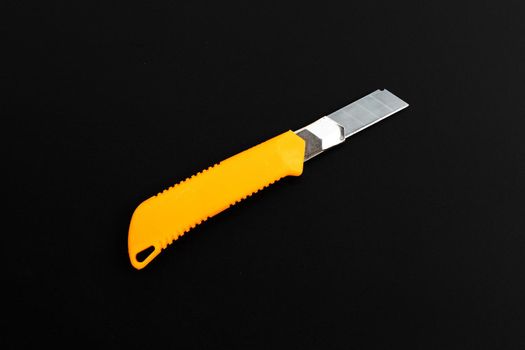 Stationery knife on dark background.