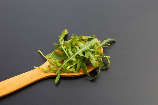 Fresh green rocket salad on dark background.
