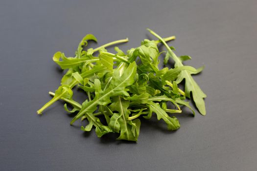 Fresh green rocket salad on dark background.