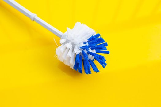 Toilet brush on yellow background. Copy space