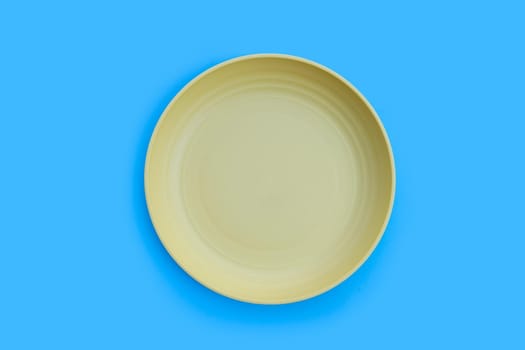 Yellow plate on blue background.  Top view