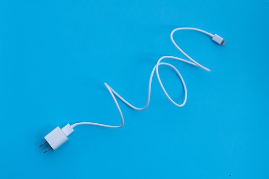 Mobile phone charger on blue background.