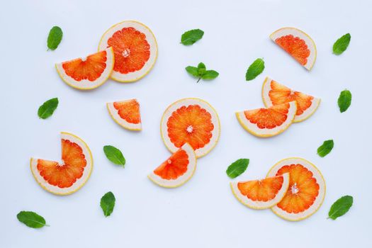 High vitamin C. Juicy grapefruit slices with mint leaves on white background.