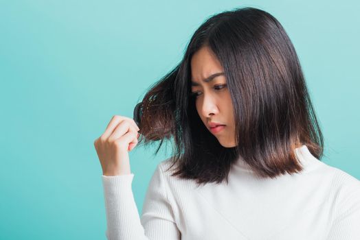 Young beautiful Asian woman upset with a comb and problem hair, Portrait female shocked suffering from hair loss problem, studio shot isolated on a blue background, medicine health concept