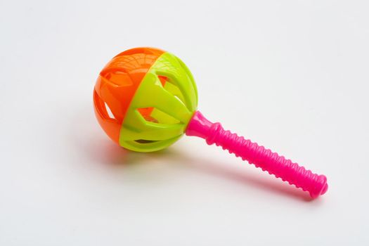 Colorful baby rattle on blue white background. 