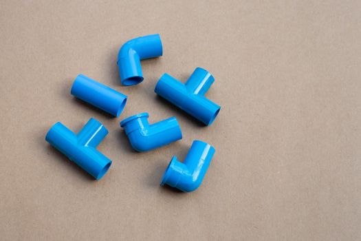 Blue pvc pipe connection on brown paper background.