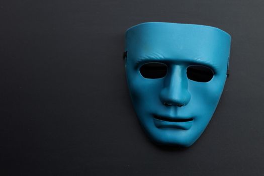 Blue face mask on dark background. Copy space