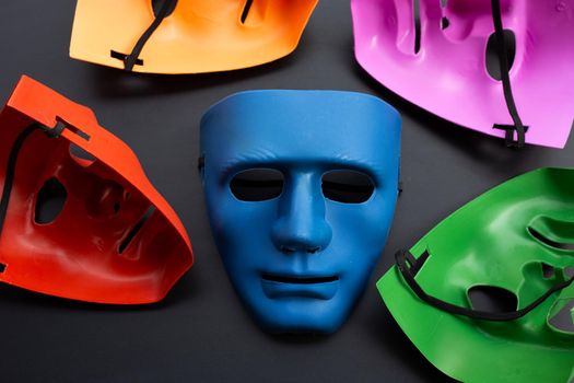Five face masks on dark background.