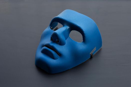 Blue face mask on dark background.