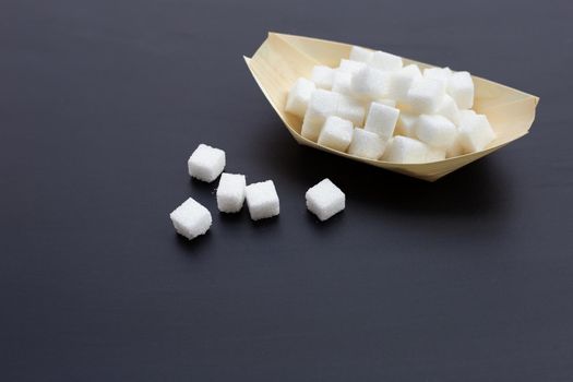 Cubes of sugar on dark background. Copy space