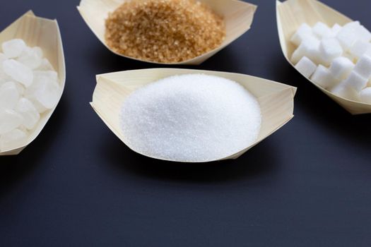 Various types of sugar on dark background.