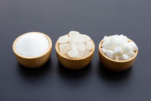 Various types of sugar on dark background.