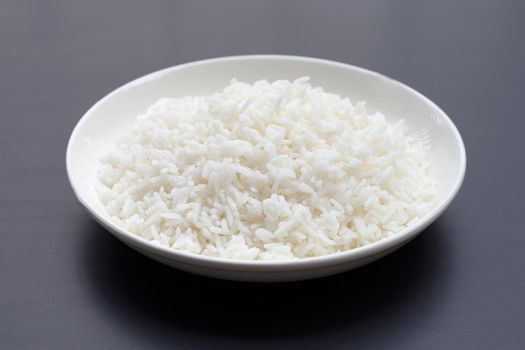 Dish of rice on dark background.