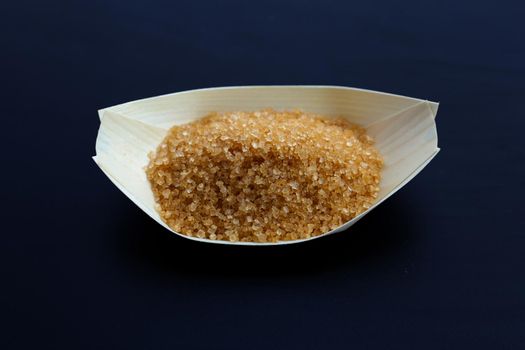 Brown sugar on dark background. Copy space