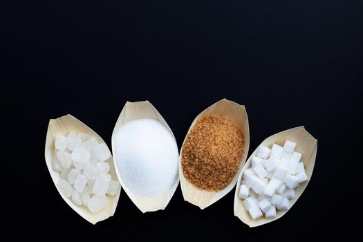 Various types of sugar on dark background.