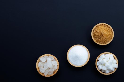 Various types of sugar on dark background.