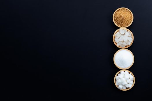 Various types of sugar on dark background.